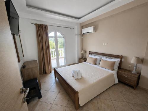 a bedroom with a bed with two towels on it at Mersina Apartments in Keri