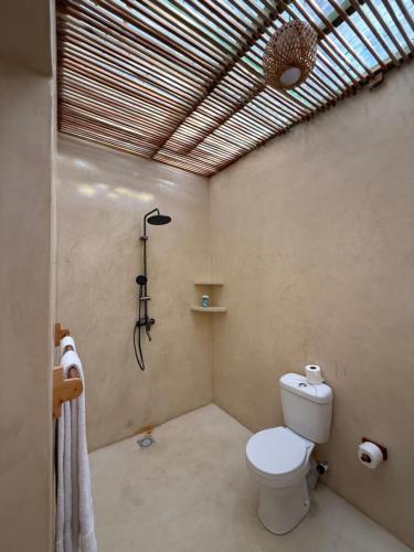 a bathroom with a toilet and a shower at Cave House in Kilifi