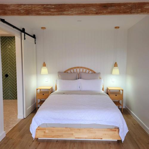 a bedroom with a white bed with two night stands at Pandanus Studio Lennox Head in Lennox Head