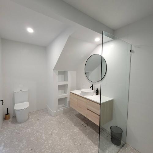 a white bathroom with a sink and a mirror at Pandanus Studio Lennox Head in Lennox Head
