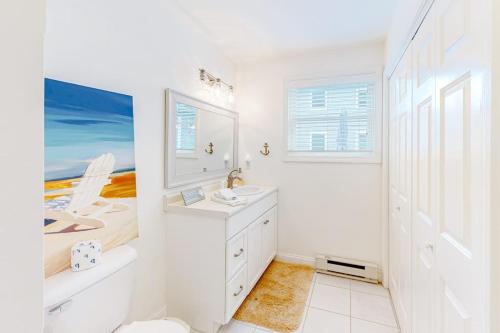 a white bathroom with a sink and a mirror at Coastal Gem in York