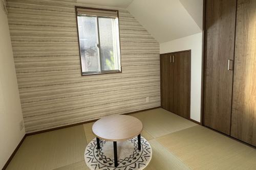 ein kleiner Hocker in einem Raum mit einem Fenster in der Unterkunft 萩別邸 シーサイド2 HAGI Bettei SEASIDE2 in Hagi