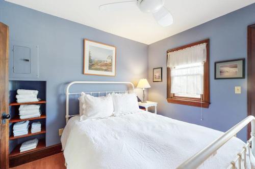 a blue bedroom with a white bed and a window at Morning on the Atlantic in Portland