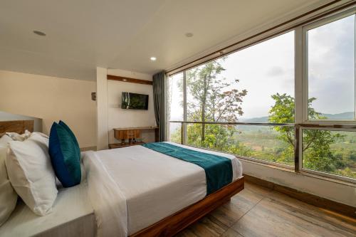 a bedroom with a bed and a large window at The Cloud by Daan in Vagamon