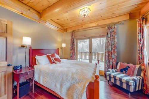a bedroom with a bed and a chair and a window at Snow Lion in Carrabassett