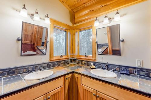 a bathroom with two sinks and two mirrors at Snow Lion in Carrabassett