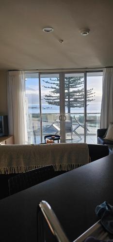 a living room with a couch and a view of the ocean at Waves Kaikoura Waterfront Apartment #1 in Kaikoura