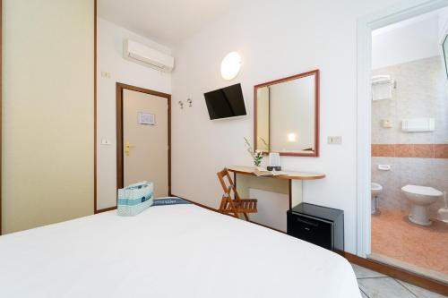 a bedroom with a bed and a bathroom with a toilet at B&B Isabella in Milano Marittima