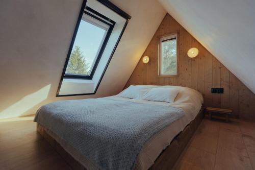 a bedroom with a bed with a large window at A Házikó in Balatonederics