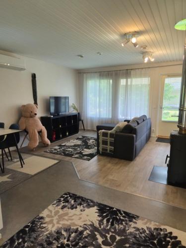 a living room with a couch and a teddy bear at Home nest in Seinäjoki