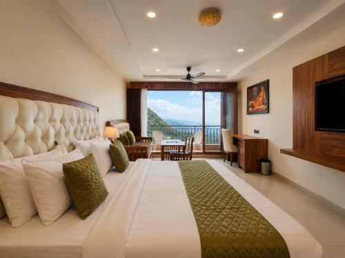 a bedroom with a large bed with a large window at The Moksh DA Hotel A Premium Property Near Jaypee Hotel in Mussoorie