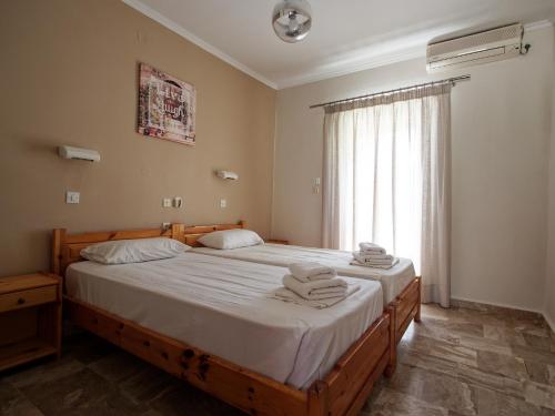two beds in a bedroom with towels on them at Rose Garden in Melíkia