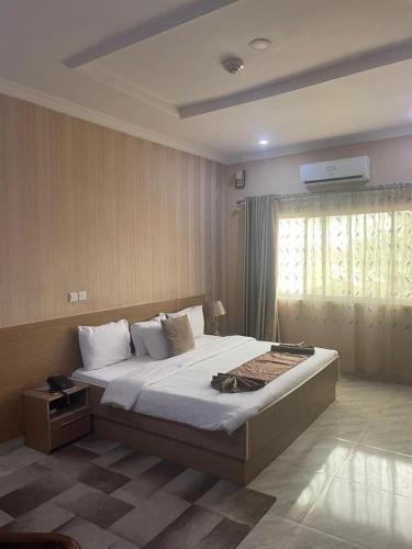 ein Schlafzimmer mit einem großen Bett und einem Fenster in der Unterkunft Fawzy Hotel in Ibadan