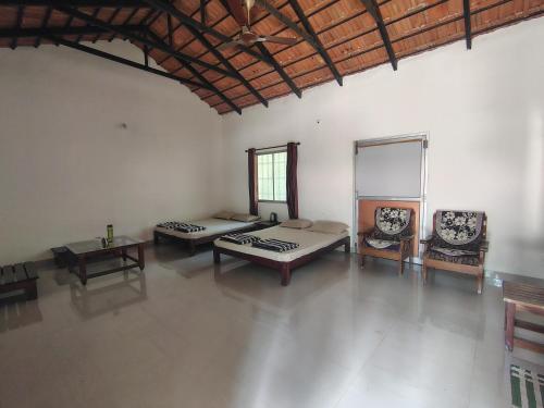 an empty room with two beds and a table at Outbackwoods homestay room Robusta in Vastāra