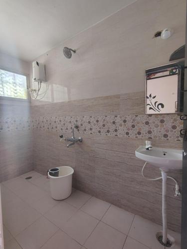 a bathroom with a sink and a toilet and a mirror at Outbackwoods homestay room Robusta in Vastāra