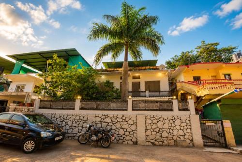 a car parked in front of a house with a palm tree at Peach stay in Mount Ābu