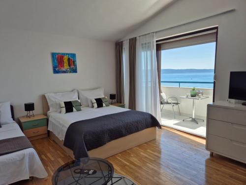 a bedroom with a bed and a view of the ocean at Apartments Zanic on The Beach in Podstrana
