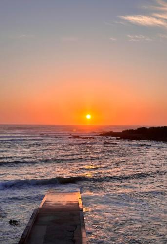 a boat in the ocean with the sunset in the background at Teresa Caeiro in Oia
