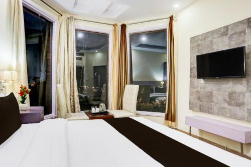 a bedroom with a large bed and a tv on a wall at Townhouse by OYO Brahma Sarovar Formerly Krishna mahal in Kurukshetra