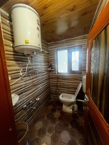 a small bathroom with a toilet and a light at Crown royal shahjee stay in Rezan