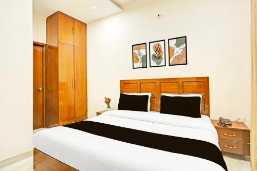 a bedroom with a large bed and a wooden headboard at Hotel O by OYO Sector 45 Formerly Manyavar in Chandīgarh