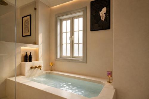 a bath tub in a bathroom with a window at YAMA Villa Udaipur in Udaipur