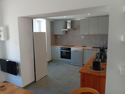 a kitchen with a refrigerator and a table in it at Tour de bridier in La Souterraine