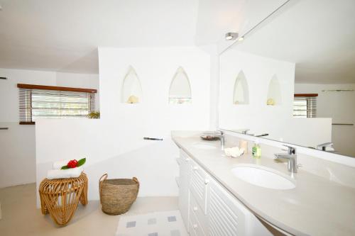 a white bathroom with a sink and a mirror at Villa Eva in Belle Mare