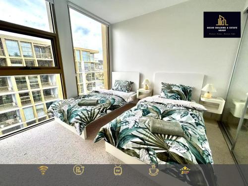 a bedroom with two beds and a window at C04-Summerfield Stylish 2BR Apart, Mountain view in Weston Creek