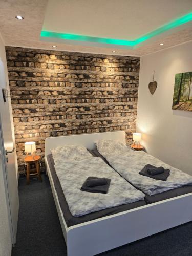 a bedroom with a bed and a brick wall at Gästehaus an der Bode wahlweise mit Halbpension PLUS in Braunlage