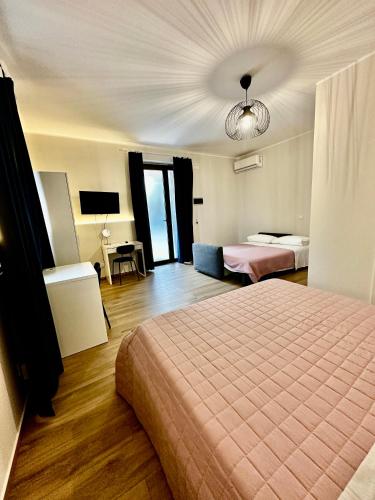 a hotel room with a bed and a room with two beds at Villa Feluchia Tra Il Mare E Il Vulcano in Acireale