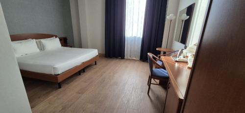 a hotel room with a bed and a desk with a desk at Hotel Le Cerbaie in Altopascio
