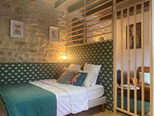 a bedroom with a bed in a room with a wall at La Rotonde in Poligny