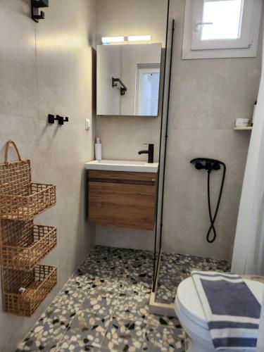 a bathroom with a sink and a toilet and a mirror at Big apartment on the beach in Tolo