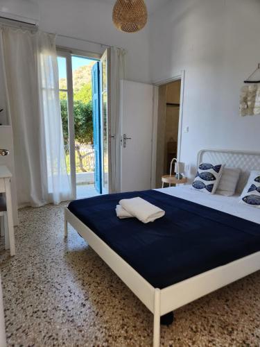 a bedroom with a large bed with a blue blanket at Big apartment on the beach in Tolo