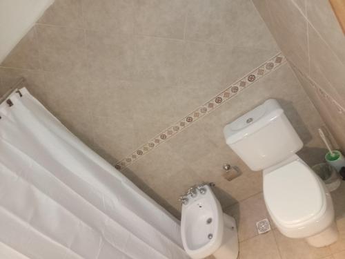 a bathroom with a toilet and a sink and a tub at Tu hogar en Concordia in Concordia