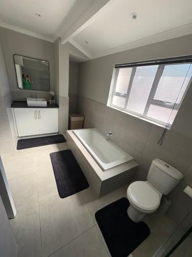 a bathroom with a tub and a toilet and a sink at Prime location in Welgemoed in Welgemoed