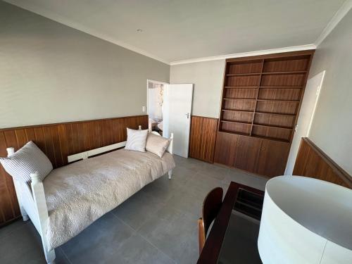 a bedroom with a bed and a wooden wall at Prime location in Welgemoed in Welgemoed