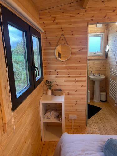 a room with a bed and a sink in a log cabin at Tobys Lodge in Laragh