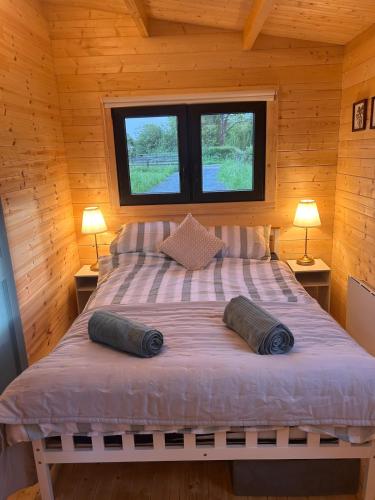 a bedroom with a bed in a wooden cabin at Tobys Lodge in Laragh