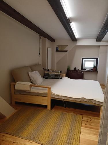 a bedroom with a bed and a couch in a room at Craft Corner Apartment Namysłów - Rynek in Namysłów
