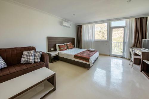 a bedroom with a bed and a couch at La Moda Beach Hotel in Kaş
