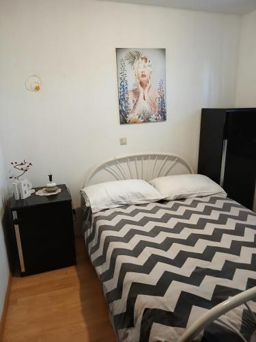 a bedroom with a bed and a picture on the wall at Vacation House Loreta in Sveti Rok