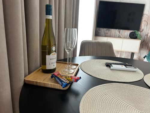 a bottle of wine and a glass on a table at Horizon Park Lux II in Boszkowo-Letnisko