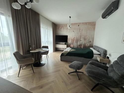 a bedroom with a bed and a table and chairs at Horizon Park Lux II in Boszkowo-Letnisko