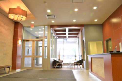 an office lobby with a large glass door and chairs at Monki Di Executive Suites - Alura in Calgary