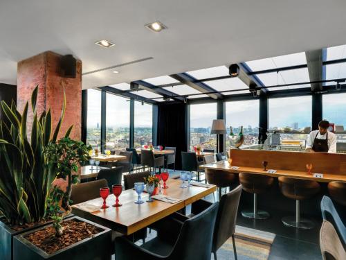 a restaurant with tables and chairs and large windows at Sense Hotel Sofia, a Member of Design Hotels in Sofia