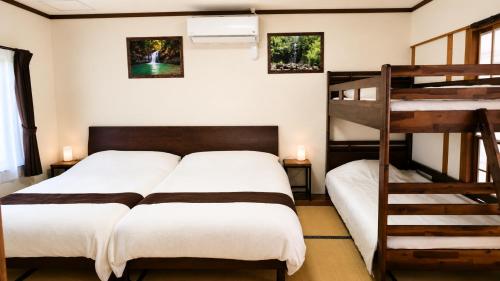 a bedroom with two beds and a bunk bed at Océanos - Sunset, BBQ, Beach & Kayak - オケアノス in Ishigaki Island