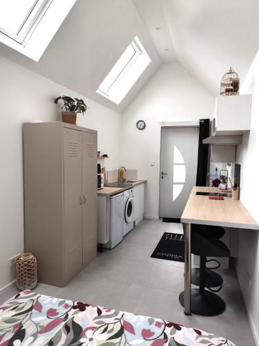 a white kitchen with a sink and a stove at La maison du hérisson in Flines-lès-Mortagne