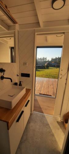 a bathroom with a sink and a large window at Tiny House Scarlet in Dziemiany